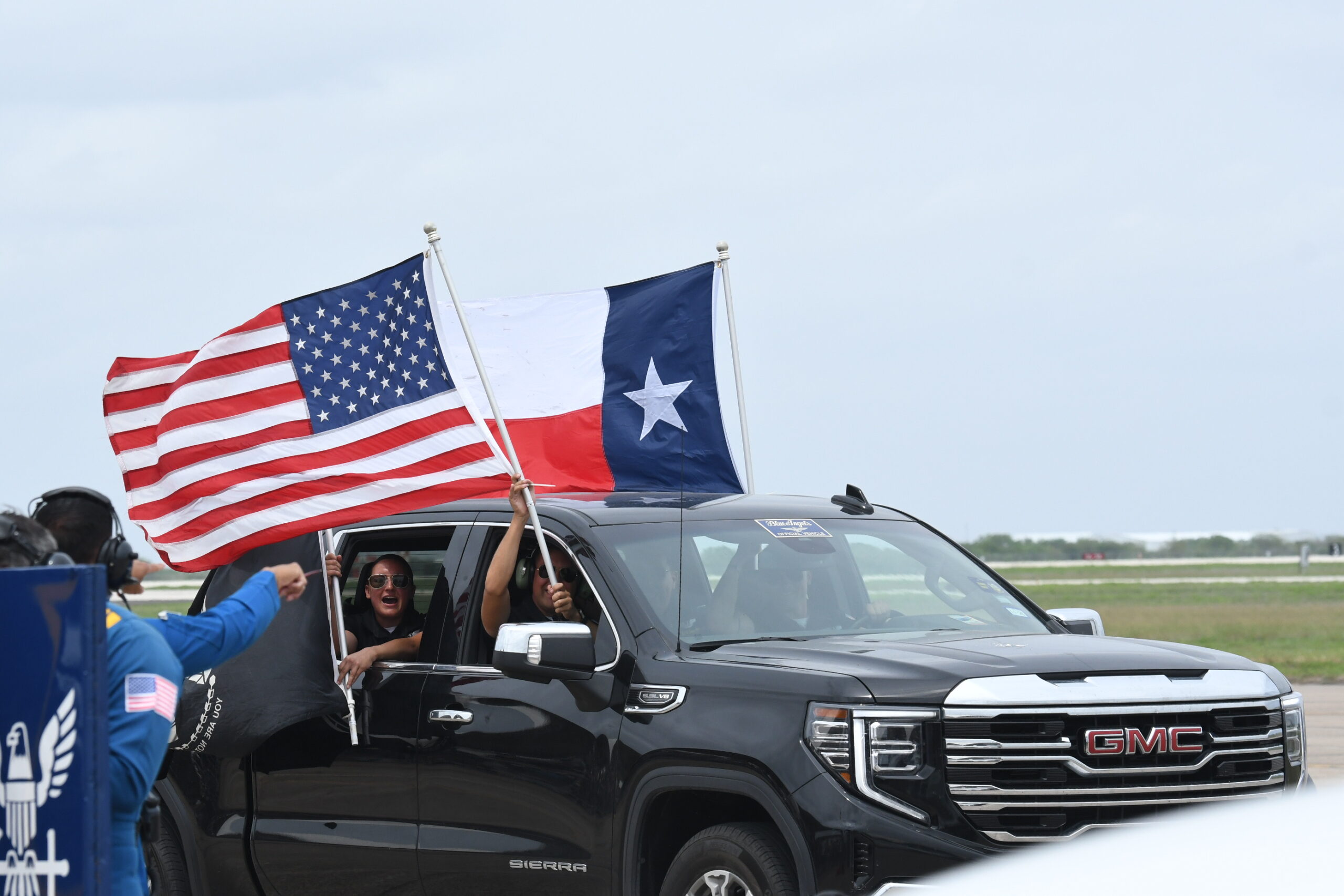 Blue Angels support team waving Texas, United States, and POW MIA flag before Blue Angels arrive.